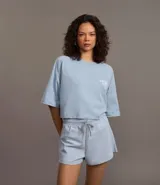 Remera corta celeste de algodón con estampado en la espalda con texto en blanco.