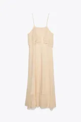 Vestido midi color crema de punto pointelle con tirantes finos y volantes en el escote.