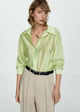 Camisa color verde claro de tejido satinado, manga larga con puños abotonados, diseño recto, cuello camisero y cierre delantero con botones.