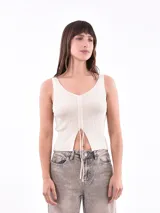 Musculosa fucsia de punto acanalado con escote en V y breteles finos. Tiene cordón ajustable en el centro del frente.