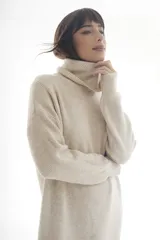 Vestido sweater largo de punto color verde oliva, con cuello alto y mangas largas.