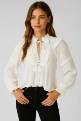 Blusa blanca de viscosa con cuello en V, volados, cordón y borlas.