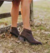 Botas cortas de cuero color marrón con cierre lateral, taco de madera de 5cm y suela de caucho.