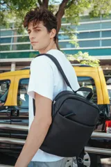 Mochila negra de cuero con cierre superior y bolsillo frontal.