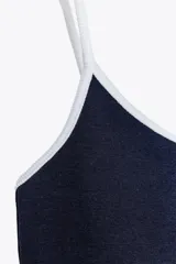 Camiseta azul marino de tirantes finos con escote redondo y detalle de ribete blanco en contraste.