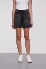 Bermuda de jean color negro con efecto lavado, tiro alto y corte holgado.