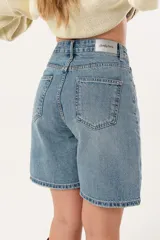 Bermuda de jean celeste, tiro alto y corte holgado.