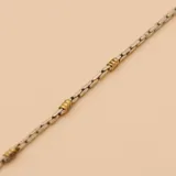 Pulsera de plata con eslabones tipo espiga cuadrada y detalles de cuentas doradas.