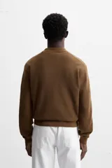 Polo marrón de punto con hilatura de algodón, corte relaxed fit, cuello solapa con cierre frontal de botonadura, manga larga y acabados en rib.