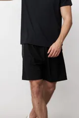 Short deportivo negro con cintura elástica y logo pequeño en la pierna.