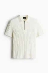 Remera polo de manga corta color crema, en tejido de punto acanalado de mezcla de algodón, con cuello clásico y medio cierre con cremallera.