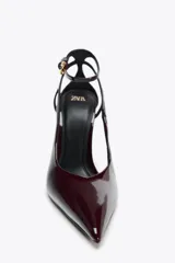 Zapato de tacón destalonado color borgoña, con efecto charol, punta fina y pulsera al tobillo con cierre de hebilla.