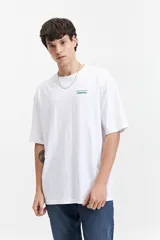 Remera blanca de manga corta con corte oversize, cuello redondo y estampado en la espalda con la frase "WHERE IMAGINATION MEETS REALITY" y el logo de la marca Mistral.