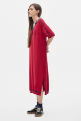 Vestido midi tejido color rojo con cuello polo a rayas azul marino y blanco, manga corta con detalle de rayas azul marino y aberturas laterales.