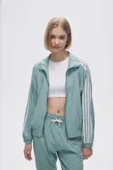 Campera deportiva verde con cierre frontal, cuello alto y tres rayas blancas en las mangas.
