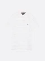 Chomba Tommy Hilfiger blanca con finas rayas horizontales celestes, corte regular, cuello clásico, tapeta de dos botones y logo bordado en el pecho.