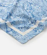 Pañuelo cuadrado de satén con estampado paisley en tonos de azul y blanco, con borde blanco.