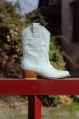 Bota texana negra de cuero con bordados y terminación en punta.