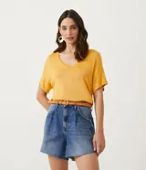 Blusa de punto color mostaza, con escote en V y mangas cortas.