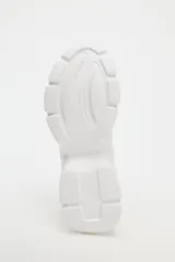 Zapatillas deportivas blancas con plataforma chunky, detalle de pespuntes y cierre con cordones.