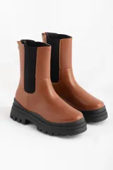 Bota media caña color marrón con elástico lateral y suela track.
