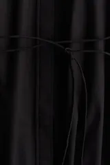 Vestido a la rodilla negro en tejido liviano de algodón con cuello redondo, botones ocultos adelante y cinturón para atar fino extraíble. Mangas al codo abullonadas en broderie con puños elásticos.
