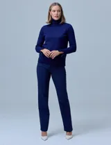 Polera de punto fino marca Nienty, color blanco, con cuello alto volcado y mangas largas con detalle de tajo en los puños.