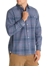Camisa de franela de algodón orgánico a cuadros en tonos azul, gris y verde. Tiene cuello camisero, manga larga, un bolsillo en el pecho y cierre con botones.