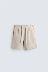 Bermuda negra de lino con calce relajado. Presenta cintura elástica ajustable con cordón, bolsillos frontales y un bolsillo trasero de plastrón.