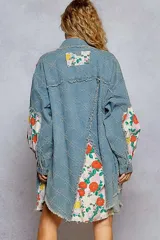 Camisa oversize de denim con detalles patchwork florales, cuello clásico, botones frontales y bordes deshilachados estilo boho.