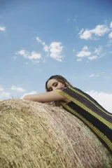 Vestido largo tejido al crochet con lurex, con diseño a rayas verticales en tonos beige y negro, y terminación con flecos.