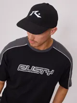 Remera de hombre azul marino con mangas y cuello amarillo, y logo de la marca Rusty estampado en el pecho.