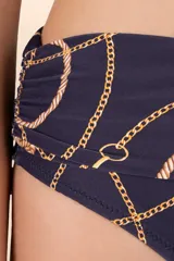 Calzón de bikini amplio azul oscuro con estampado de cadenas y cuerdas doradas. Presenta una faja que define la silueta, recogidos laterales y corte a la cadera.