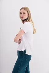 Remera blanca de algodón peruano, de corte ajustado y escote en V pronunciado.