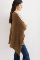 Poncho color beige de algodón tejido, con moldería oversize y tajos en los laterales.