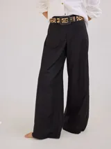 Pantalón negro de tiro medio alto con pretina elastizada en la espalda, pierna ancha y bolsillos plaque en delantera y espalda.