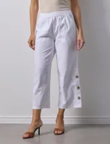 Pantalón blanco de algodón con pretina elastizada, bolsillos inclinados y ruedo con botones.