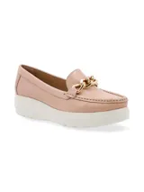 Mocasín de cuero charol negro con plataforma blanca y detalle de hebilla metálica plateada en el empeine.