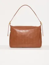 Cartera hobo color marrón confeccionada en cuero vacuno flor, con acceso mediante cierre superior y correa regulable con hebillas metálicas.