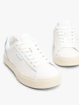 Zapatillas blancas de cuero con cordones, suela cupsole color crema y talón celeste.