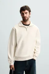 Sudadera color crema de corte recto, con cuello polo y cierre de cremallera metálica.