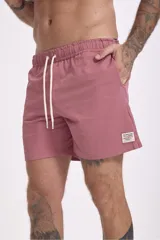 Short de baño color verde oliva con textura de rayas finas en relieve y cordón de ajuste blanco en la cintura.