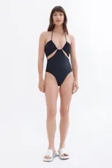 Traje de baño enterizo negro con breteles finos y aberturas en la zona del abdomen.