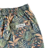 Short de baño azul con estampado de hojas en tonos verde y naranja. Cuenta con elástico en la cintura, cordón ajustable, tres bolsillos y mesh interior hipoalergénico.
