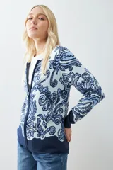 Chaqueta tejida color verde agua con estampado floral en azul marino, de corte recto y cuello redondo.