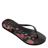 Sandalias tipo ojota Havaianas modelo Slim Organic, color negro con estampado floral en tonos rosados y beige, y líneas onduladas doradas. Poseen tiras finas negras.