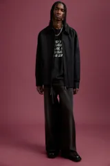 Remera negra de corte holgado con estampado frontal con la frase "Keep your friends close and your enemies far away".