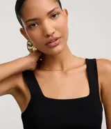 Blusa de punto color negro, con escote cuadrado, breteles anchos y corte peplum.