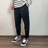 Pantalón jean negro de corte slouchy, con tiro alto y largo al tobillo.