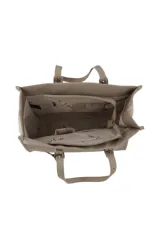 Cartera tipo tote color beige con doble asa de hombro, logo circular de la marca en el centro y llavero colgante con forma de labios.